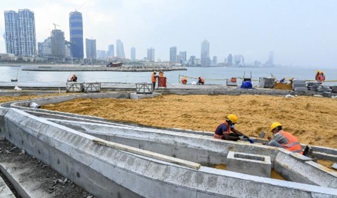  Des ouvriers travaillent sur le chantier de construction sur des terres récupérées dans le cadre du projet financé par la Chine pour Port City, à Colombo, le 28 octobre 2021. (Photo, AFP)