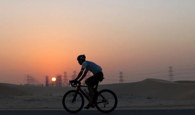 Des passionnés de vélo roulent sur la piste cyclable d'al-Qudra dans le désert de Dubaï, le 30 octobre 2021 (Photo, AFP)