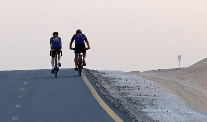 Des passionnés de vélo roulent sur la piste cyclable d'al-Qudra dans le désert de Dubaï, le 30 octobre 2021 (Photo, AFP)
