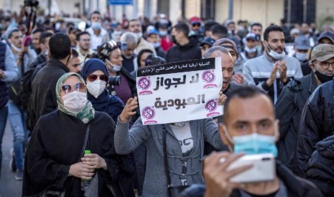 Un manifestant marocain lève une pancarte qui lit en arabe «Non au laissez-passer esclavage» lors d'une manifestation dans la ville de Rabat, le 7 novembre 2021 (Photo, AFP)