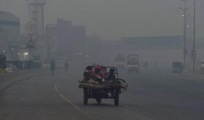 Les gens font la navette le long d'une rue dans des conditions de smog intense à Lahore, le 18 novembre 2021. (Photo, AFP)