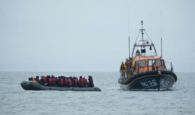 Les migrants sont aidés par le canot de sauvetage de la RNLI (Royal National Lifeboat Institution) avant d'être emmenés sur une plage de Dungeness, sur la côte sud-est de l'Angleterre, le 24 novembre 2021, après avoir traversé la Manche. (Photo, AFP)