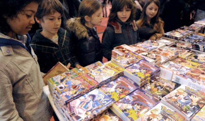 Des enfants regardent des mangas, livres de dessins animés japonais, exposés lors du 32e Salon du livre de Paris, le 19 mars 2012 à Paris. (Photo, AFP)