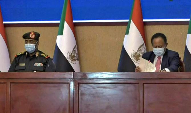 Le général soudanais Abdel Fattah Al-Burhan (à gauche) et le Premier ministre Abdalla Hamdok signent un accord pour rétablir la transition vers un régime civil dans le pays, le 21 novembre 2021. (Photo, AFP)