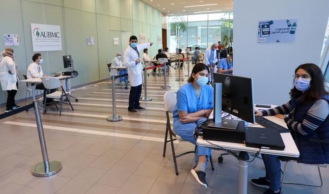 Un infirmier aide une patiente pendant que d'autres attendent dans un couloir du Rafic Hariri University Hospital, au Liban, qui imposera un couvre-feu nocturne à partir du 17 décembre et pendant trois semaines aux personnes non vaccinées. (STR/AFP via Getty Images) Un infirmier aide une patiente pendant que d'autres attendent dans un couloir du Rafic Hariri University Hospital, au Liban, qui imposera un couvre-feu nocturne à partir du 17 décembre et pendant trois semaines aux personnes non vaccinées. (STR/AFP via Getty Images)