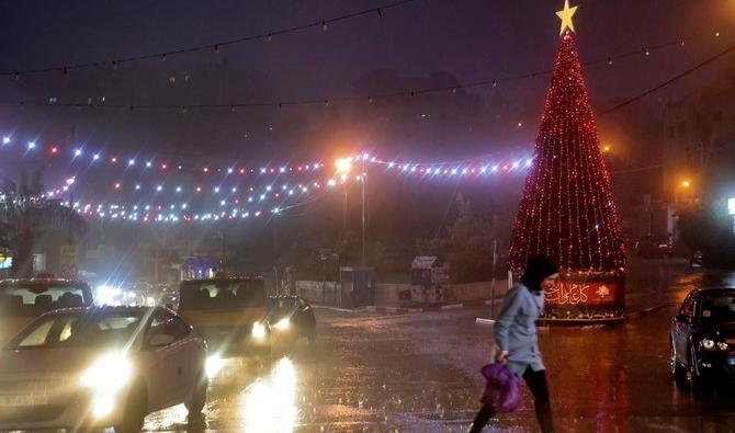 Une Palestinienne traverse une route sous la pluie lundi en Cisjordanie. (AFP)