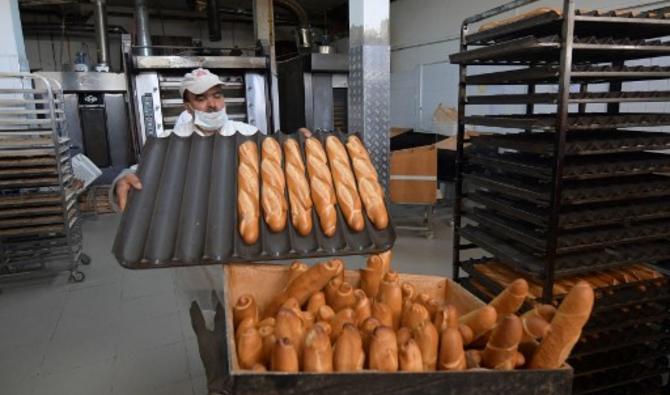 Un ouvrier range du pain dans un panier dans une boulangerie du quartier d'El Menzah à Tunis, le 27 février 2022. (Photo, AFP)