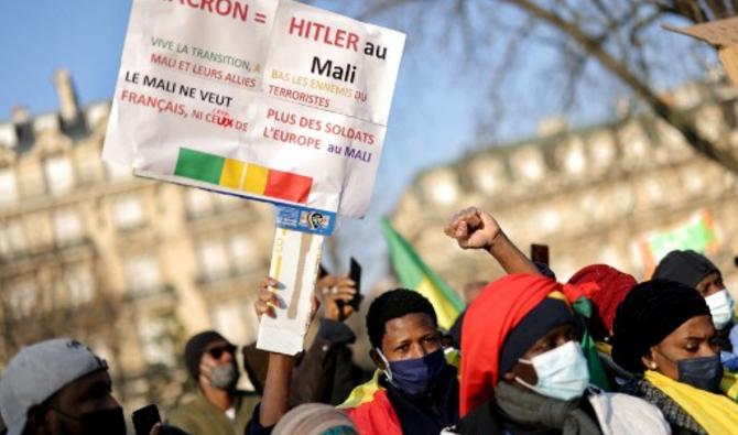 Un partisan de la junte militaire au pouvoir, tient une banderole indiquant « Macron = Hitler du Mali » lors d'une manifestation contre la France, près de l'ambassade du Ghana à Paris, le 15 janvier 2022. (Photo, AFP) 