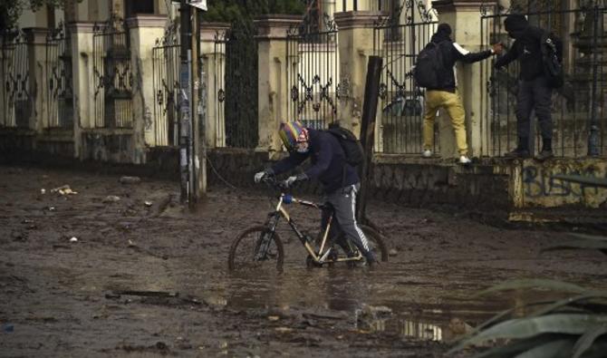 Un homme à vélo tente de traverser une rue boueuse dans le nord de Quito, le 1er février 2022. (Photo, AFP)