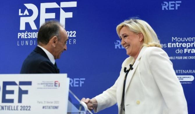 Les candidats à la présidentielle Eric Zemmour et Marine Le Pen se serrent la main en se croisant lors de la présentation de leurs programmes de campagne économique au Medef à Paris, le 21 février 2022. (Photo, AFP)