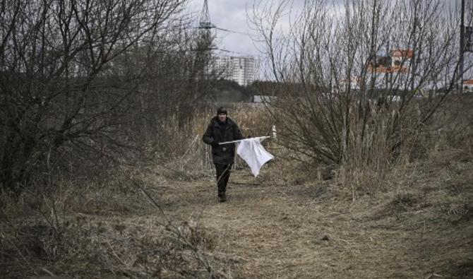 Un homme marche avec un drapeau blanc alors que les gens fuient la ville d'Irpin, à l'ouest de Kiev, le 7 mars 2022. (Photo, AFP)