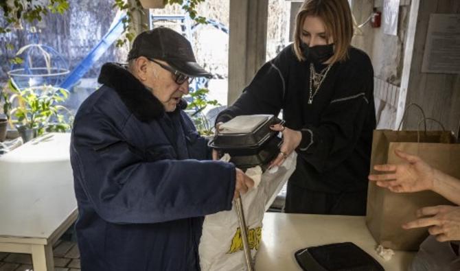 Un membre du personnel du restaurant de luxe Tchernomorka distribue de la nourriture gratuite aux résidents dans le besoin, à Kiev le 19 mars 2022. (Photo, AFP)