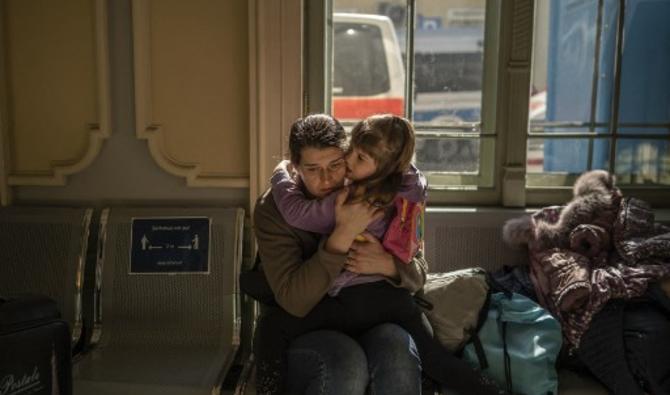 Un évacuée ukrainienne embrasse son enfant dans la gare de Przemysl, près de la frontière polono-ukrainienne, le 22 mars 2022. (Photo, AFP)