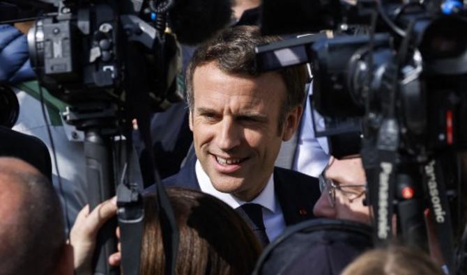 Emmanuel Macron entouré de journalistes alors qu'il arrive pour une visite au lycée Marcs d'Or à Dijon, le 28 mars 2022. (Photo, AFP)