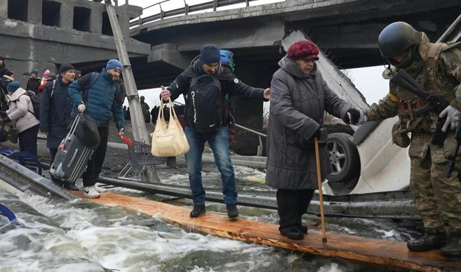 La planche de bois de 50cm de large est à moitié enfoncée l'eau glacée de la rivière d'Irpin. (Photo, AFP)