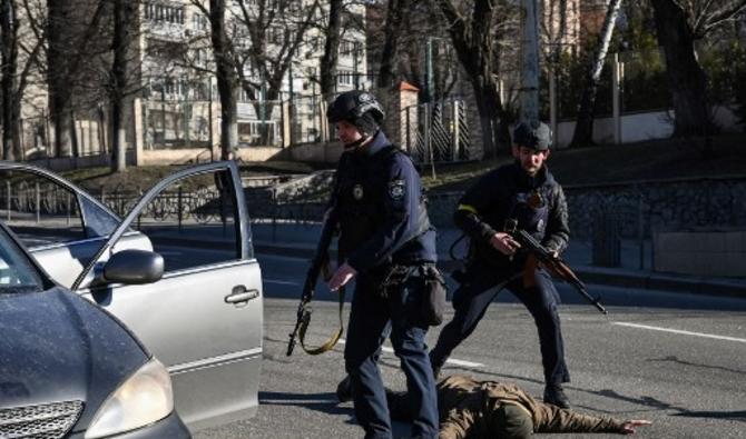 Des policiers ukrainiens arrêtent des voitures pour contrôler des personnes à la recherche d'hommes suspects, le 27 février 2022, dans une rue de Kiev. (Photo, AFP)