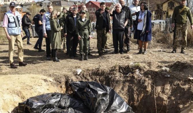 Le chef humanitaire de l'ONU Martin Griffiths sur le site d'une fosse commune que les Ukrainiens avaient creusée près d'une église, le 7 avril 2022, lors de sa visite de trois heures à Boutcha. (Photo, AFP)