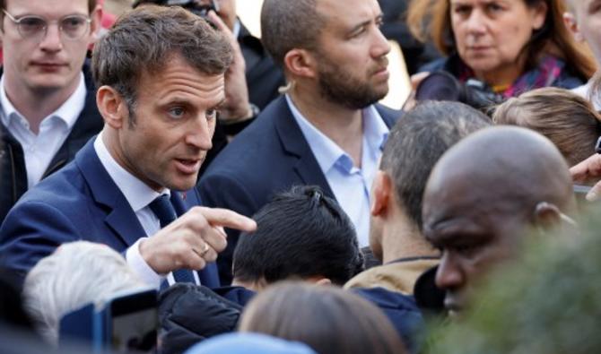 Emmanuel Macron entouré par des journalistes lors d'un point presse devant la mairie de Denain. (Photo, AFP)