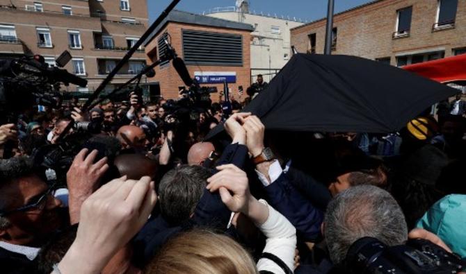 Le service d'ordre du chef de l'Etat a brièvement déployé un « parapluie » destiné à le protéger avant que le président ne se rende au marché couvert. (Photo, AFP)