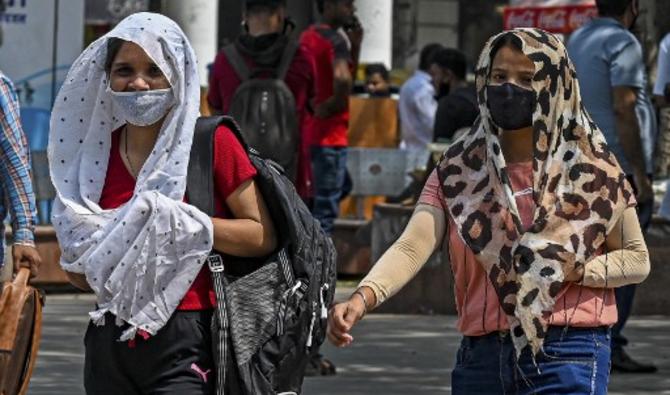 Des filles se couvrent la tête d'un tissu pour s'abriter de la chaleur, à New Delhi, le 28 avril 2022. (Photo, AFP)
