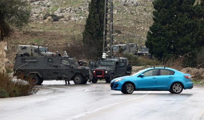 Les forces de sécurité israéliennes bloquent la route menant au site de la fusillade près de Homesh, un avant-poste israélien illégal qui avait été précédemment évacué par le gouvernement, en Cisjordanie occupée, le 17 décembre 2021. (Photo, AFP)
