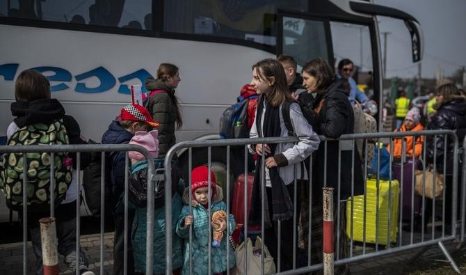 Des réfugiés ukrainiens attendent de monter dans un bus après avoir traversé la frontière ukrainienne avec la Pologne au poste frontière de Medyka, dans le sud-est de la Pologne. (Photo, AFP) 