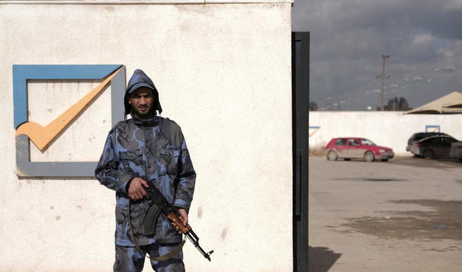 Un agent de sécurité garde la façade du bâtiment de la Haute Commission électorale nationale à Benghazi, en Libye. (Reuters)