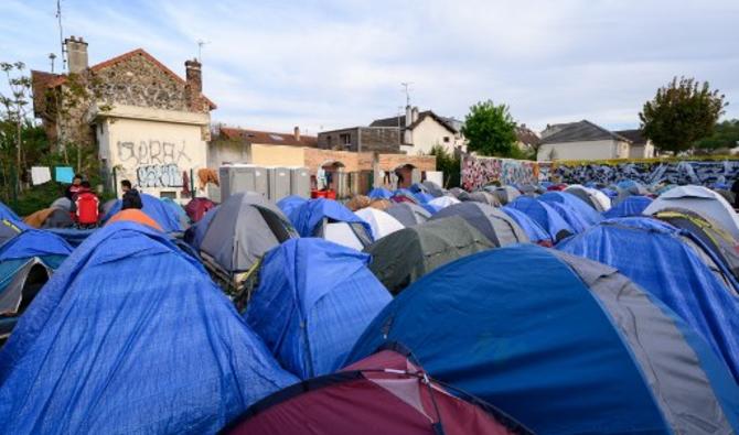 Des demandeurs d'asile, principalement d'Afghanistan, se tiennent près de leurs tentes dans un camp de migrants de fortune à Pantin, dans la banlieue nord-est de Paris, le 20 avril 2022. (Photo, AFP)