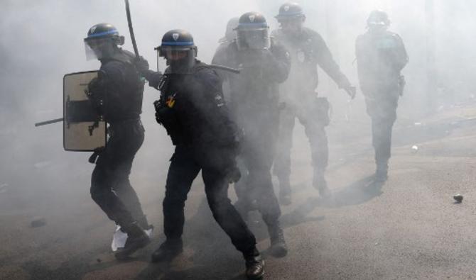 Des policiers, entourés de gaz lacrymogènes, font face à des manifestants lors de la fête annuelle du 1er mai (fête du travail), à Paris, le 1er mai 2022. (Photo, AFP)