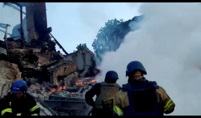 L'équipe d'urgence s'occupe d'un incendie près de débris en feu, après qu'un bâtiment scolaire a été touché à la suite d'un bombardement, dans le village de Bilohorivka, Luhansk, Ukraine, le 8 mai 2022. (Reuters)