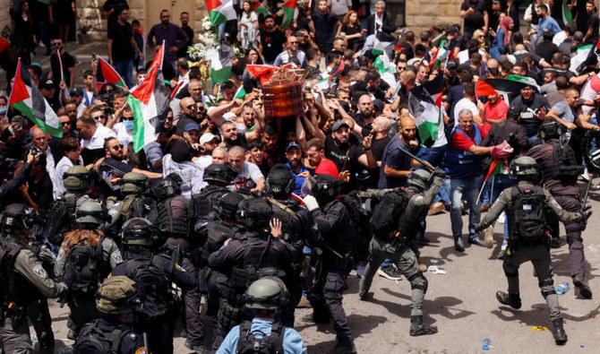 La famille et les amis portent le cercueil de la journaliste d'Al Jazeera Shireen Abu Akleh alors que des affrontements ont éclaté avec les forces de sécurité israéliennes lors de ses funérailles à Jérusalem, le 13 mai 2022. (Reuters)