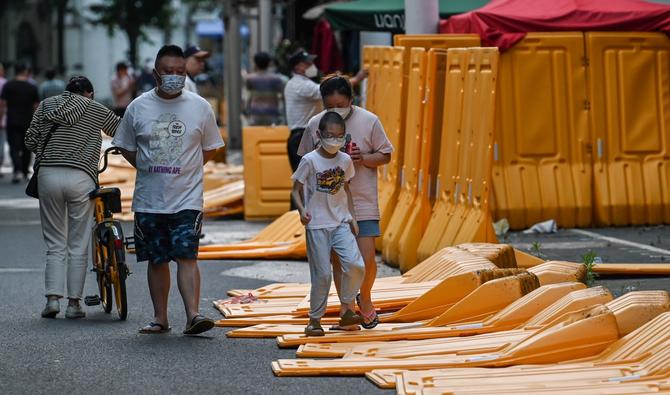 Un garçon franchit des barrières, érigées le 19 mars selon les résidents locaux dans le cadre des fermetures pandémiques dans la région et démontées plus tôt cet après-midi, dans le quartier Jing' an de Shanghai le 31 mai 2022. (Photo, AFP)