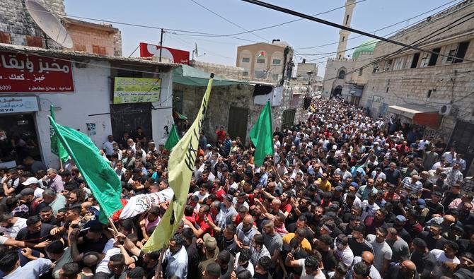 Des personnes en deuil portent le corps drapé d'un drapeau d'un jeune Palestinien, tué lors d'affrontements avec les troupes israéliennes dans la ville de Yabad près de Jénine un jour plus tôt, lors de ses funérailles, le 2 juin 2022. (Photo, AFP)