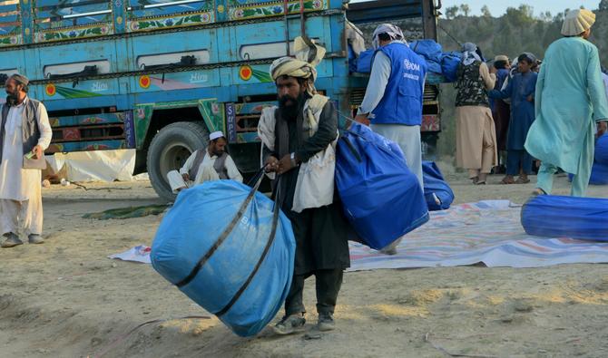 Des volontaires transportent l'aide reçue de l'Organisation internationale pour les migrations (OIM) pour les personnes touchées par le récent séisme dans le village Afghan-Dubaï, dans l'est de la province de Khost, le 26 juin 2022. (Photo, AFP)