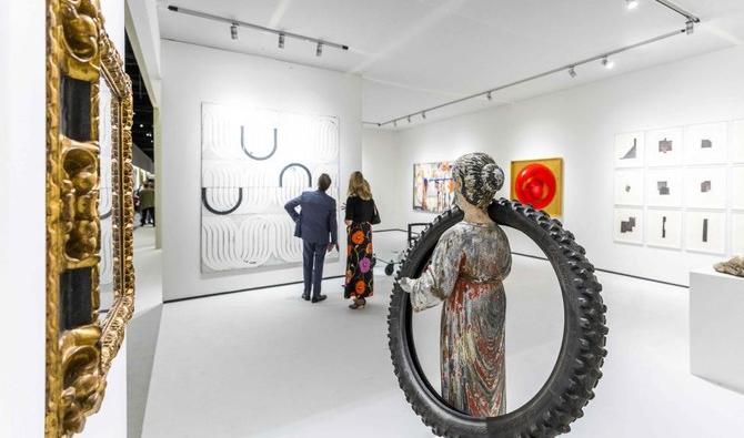 Les visiteurs regardent les expositions lors de la 35e édition de la foire internationale d'art et d'antiquités Tefaf Maastricht samedi. (Photo, AFP))
