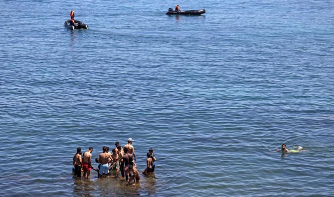 Des officiers de la Marine royale marocaine interceptent des migrants dans l'eau à la frontière entre le Maroc et l'enclave espagnole de Ceuta, le 19 mai 2021, à Fnideq. (Photo, AFP)