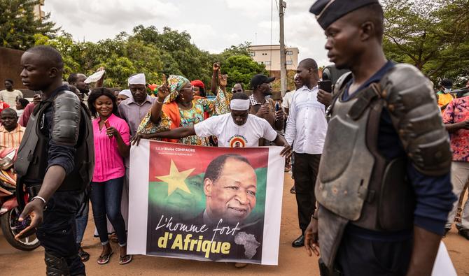 Un homme tient une affiche de l'ancien président du Burkina Faso Blaise Compaoré, devant l'aéroport de Ouagadougou le 7 juillet 2022. (Photo, AFP)