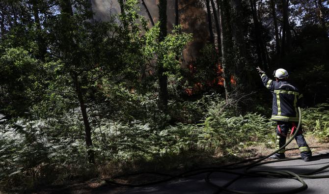 Un pompier lutte contre un incendie de forêt qui s'est déclaré au pied de la Dune du Pilat près de La Teste-de-Buch, dans le sud-ouest de la France, le 13 juillet 2022. (Photo, AFP)