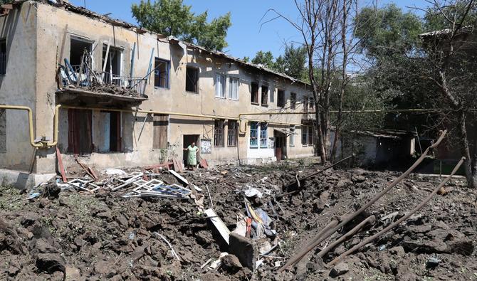 Une femme se tient devant sa maison détruite à la suite d'une frappe aérienne russe dans la ville de Toretsk, dans la région de Donetsk, le 17 juillet 2022. (Photo, AFP)