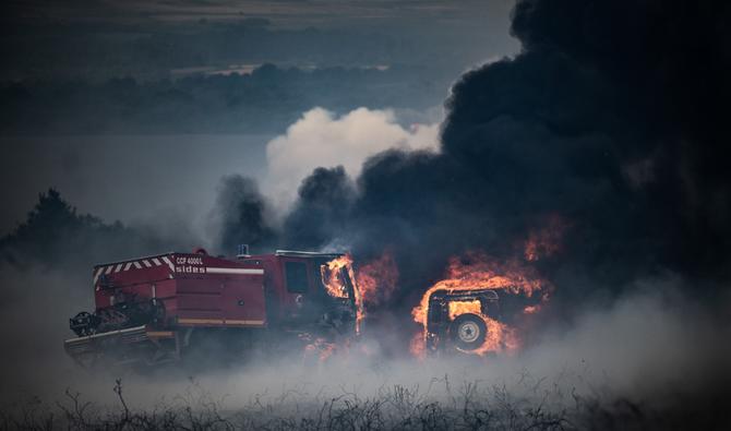 Une photo prise le 19 juillet 2022 montre des camions de pompiers brûlant lors d'un incendie de forêt sur le Mont d'Arrées, à l'extérieur de Brasparts, dans l'ouest de la France. (Photo, AFP)