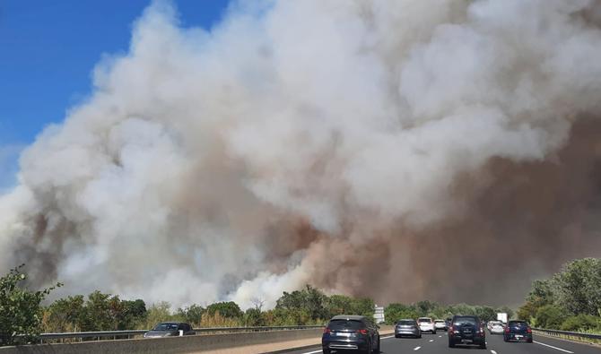 Cette image prise depuis la fenêtre d'une voiture le long d'une autoroute le 31 juillet 2022 montre une épaisse fumée blanche provenant d'un incendie près d'Aubais, dans le sud de la France. (Photo, AFP)