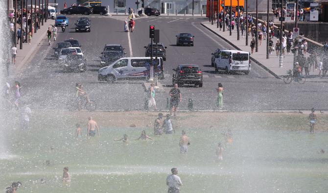 Les gens se rafraîchissent à la fontaine du Trocadéro par un après-midi d'été ensoleillé à Paris, le 3 août 2022. (Photo, AFP)