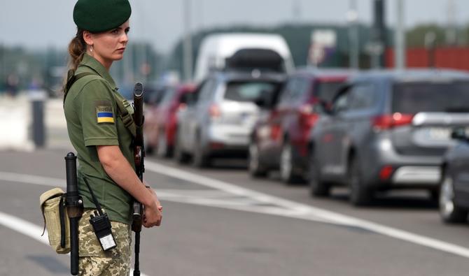 Un agent de sécurité des frontières monte la garde au point de contrôle de Krakivets-Korczowa à la frontière entre l'Ukraine et la Pologne à environ 70 km de la ville de Lviv, le 16 août 2022. (Photo, AFP)
