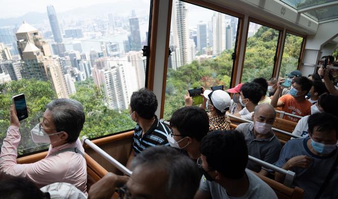 Les passagers prennent des photos de la ligne d'horizon de Hong Kong alors qu'ils empruntent le Peak Tram de sixième génération récemment rénové lors de son premier jour de fonctionnement à Hong Kong, le 27 août 2022. (Photo, AFP)
