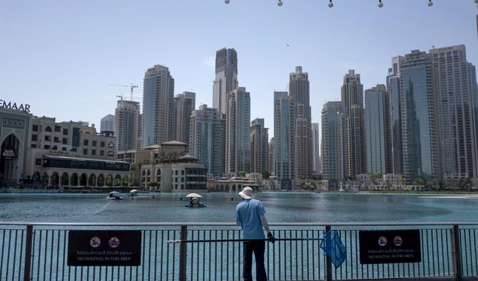 Un homme se tient près d'un lac à l'extérieur du centre commercial du centre-ville, le 31 août 2022 à Dubaï. (Photo, AFP)