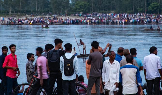 Des gens se rassemblent le long des rives de la rivière Karatoya au lendemain du naufrage dans une rivière du Nord du Bangladesh d'un bateau transportant des pèlerins hindous. (Photo, AFP)