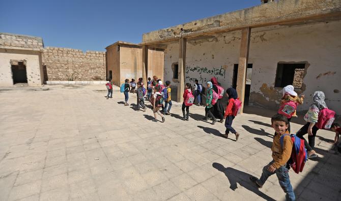 Des filles portant des cartables roses et des garçons avec des cartables bleus jouent dans la cour de leur école à Tadif, à 32 kilomètres à l'est de la ville d'Alep, le 26 septembre 2022. (Photo, AFP)