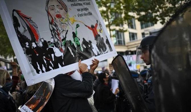 Des personnes se tiennent face à la police antiémeute lors d’une manifestation de soutien aux manifestants iraniens à Paris. (AFP)
