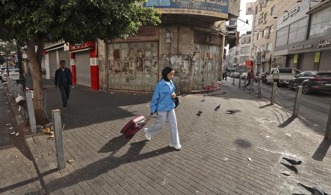 Des Palestiniens marchent dans une rue vide à Ramallah en Cisjordanie occupée le 20 octobre 2022 lors d'une grève générale pour protester contre le meurtre d'un fugitif palestinien. (Photo, AFP)