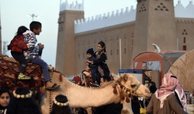 Des enfants saoudiens montent à dos de chameau lors d’un festival, organisé dans le village saoudien d’Al-Thamama, qui vise à promouvoir le patrimoine et la culture . (AFP)